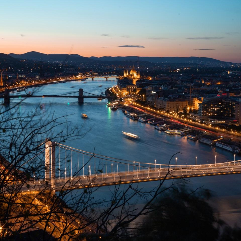 a bridge over a river with a city in the background